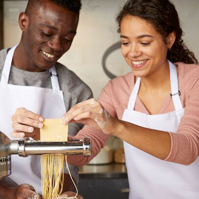 two people making homemade pasta noodles
