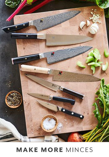 chef's knives and paring knives on wooden cutting board