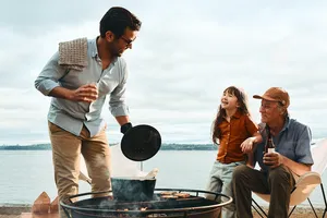 father and son barbecuing on the beach