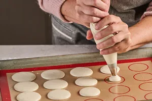 Making French macarons with pastry bag