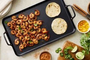 Cast iron griddle with shrimp and tortillas