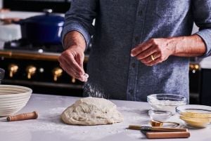 chef kneading fresh bread dough