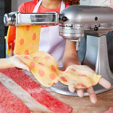 kids making pasta sheets with KitchenAid stand mixer attachment