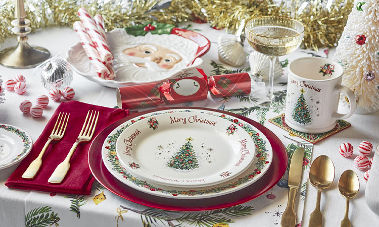 Holiday table with Merry Christmas dinnerware and gold flatware