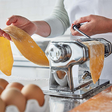 Pasta Makers rolling fresh pasta sheet
