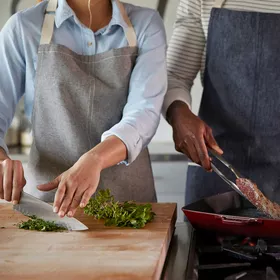 Chefs chopping herbs and searing steak