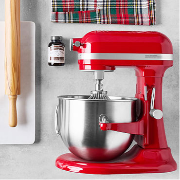 Red KitchenAid stand mixer with rolling pin and vanilla