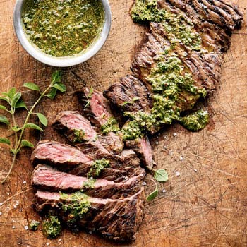 Flank Steak sliced and topped with chimichurri sauce