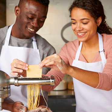 Two chefs making fresh pasta