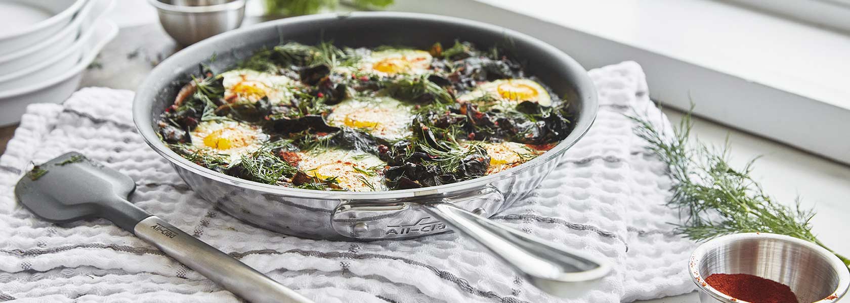 All-Clad stainless steel skillet with green shakshuka