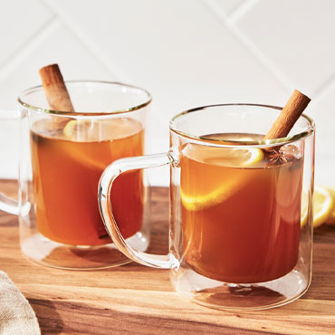 Hot Toddy Cocktails with cinnamon sticks in glass mugs