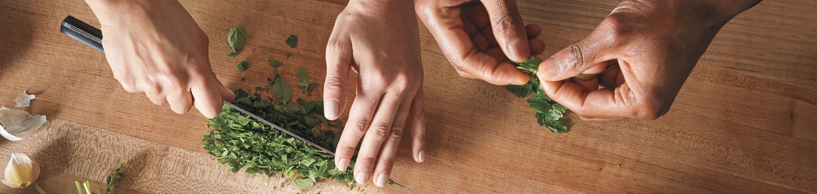 two chefs prepping herbs