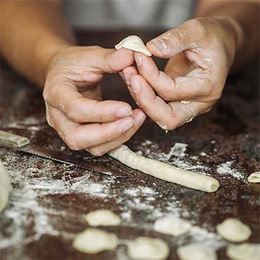 Hands forming fresh pasta orecchiete