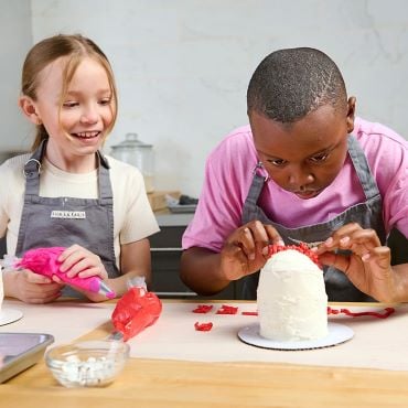 Girl and Boy decorating monster cakes in Sur La Table kitchen