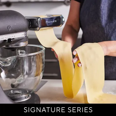 Fresh pasta dough being rolled out from KitchenAid pasta attachment