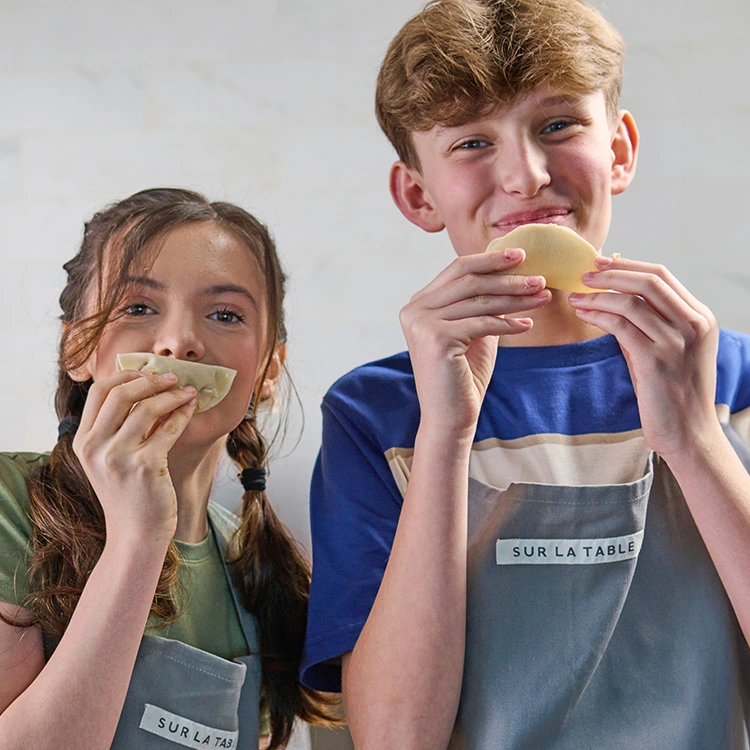 Teen boy and girl making dumpling wrapper dough