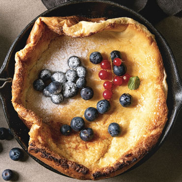 Skillet Soufflé Pancake with Lemon Syrup and Blackberries