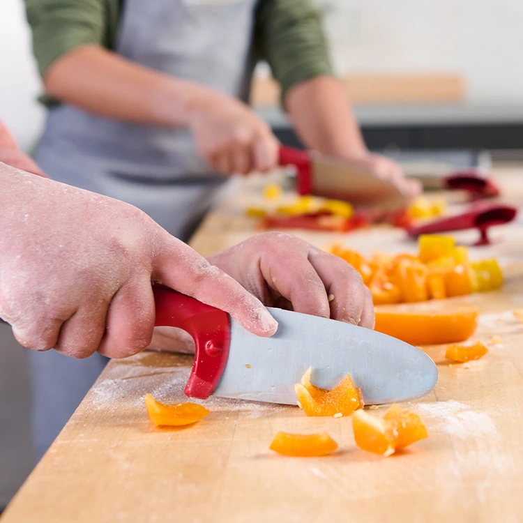 Kids chopping yellow bell peppers on wooden counter