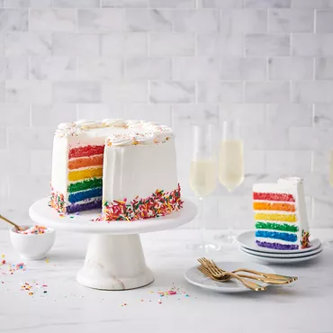Rainbow Cake with White Frosting and sprinkles