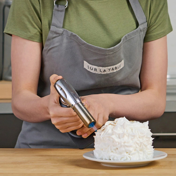 teen chef using torch to toast meringue topping