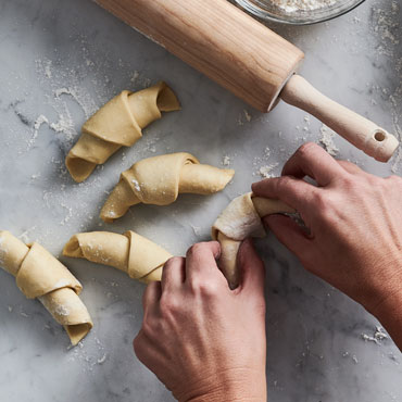 hands forming fresh croissant dough