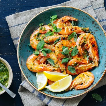 Prawns with Chermoula Sauce with lemon on blue plate
