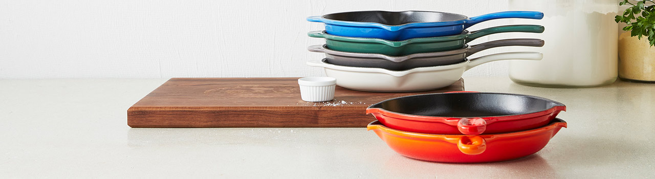 Le Creuset cast iron skillets in various colors