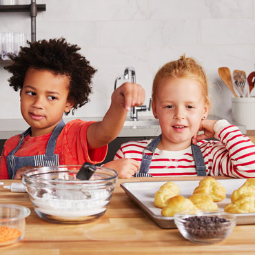 Boy and girl making pastries in kitchen