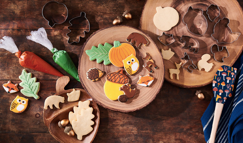 Pumpkin, acorn, owl and hedgehog cookie cutters with decorated fall cookies