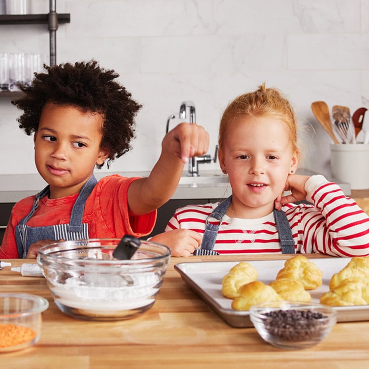 Two kids making pastries