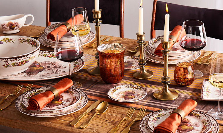Thanksgiving table with turkey dinnerware and gold flatware