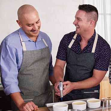 male couple making creme brulee in kitchen