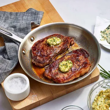 Seared Steaks in skillet with Herbed Butter