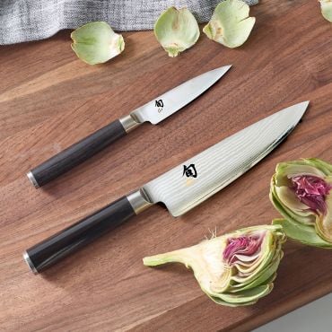 Shun Classic Knives with artichokes on cutting board